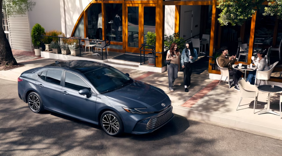 Redesigned 2026 Toyota Camry hybrid sedan parked outside a local cafe in Waukegan, IL, showcasing its athletic front fascia and premium alloy wheels
