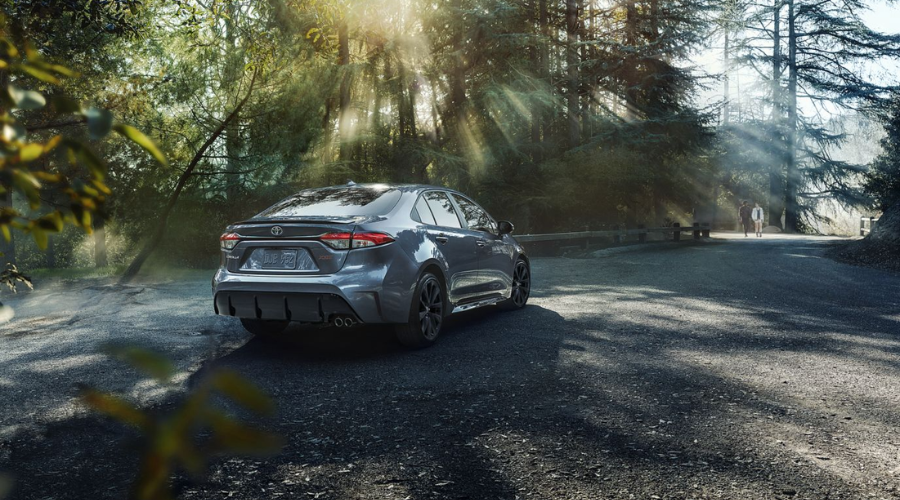 Rear view of a gray 2026 Toyota Corolla parked on a tree-lined Lake County road, showcasing the perfect commuter car for Waukegan and Gurnee, IL drivers.