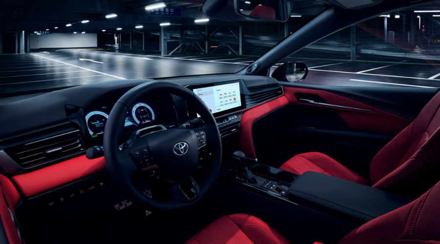 Sporty interior cockpit of the 2026 Toyota Camry featuring red leather trim and digital displays, parked in a Lake County, IL garage